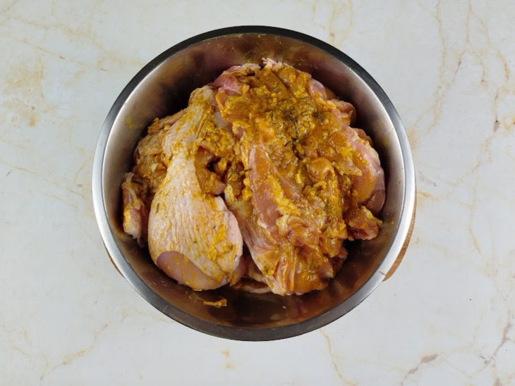 Numa tigela, as sobrecoxas, o suco de limão e os temperos.