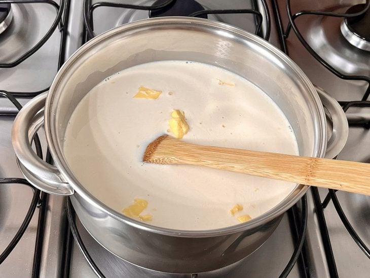 Uma panela contendo a mistura de leite, amido de milho, leite condensado, manteiga e baunilha.