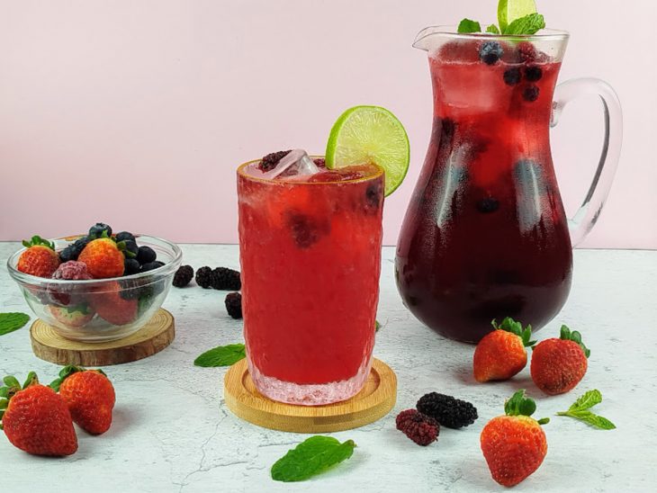 Soda italiana com chá de frutas vermelhas pronto para consumo em um copo de vidro.