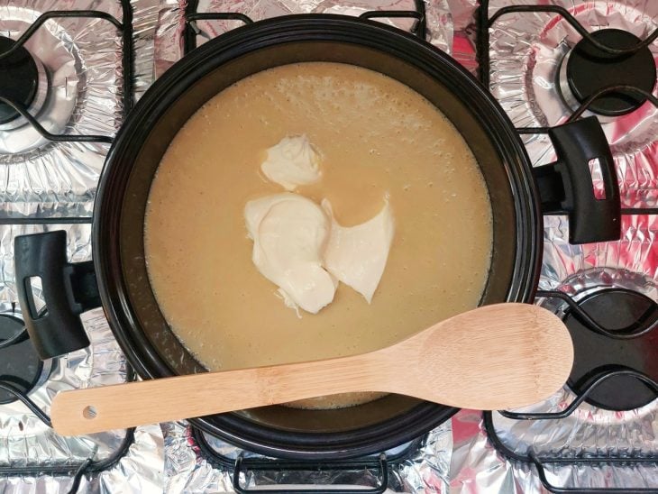 Fondue adicionado na panela com a mistura e uma colher por cima.
