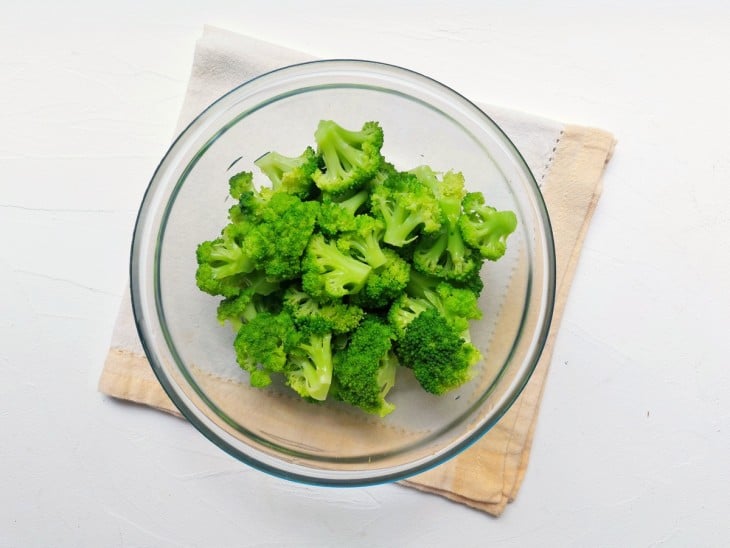 Um recipiente com brócolis cozidos.