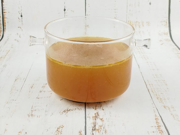 Caldo coado após o cozimento do frango e dos legumes.