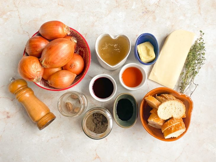 Ingredientes para a receita de sopa de cebola reunidos em uma bancada.
