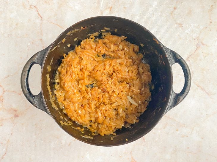 Cebola com manteiga em uma panela.