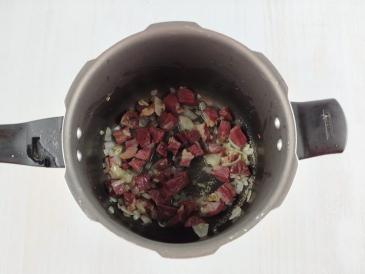 Charque escaldada adicionada na panela.