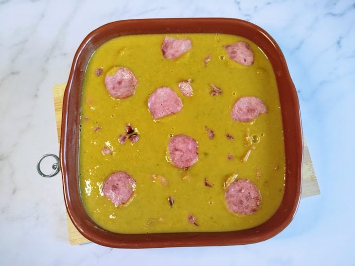 Um recipiente contendo sopa de ervilha.