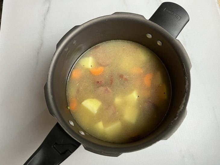 Batata, cenoura e água adicionada na panela.