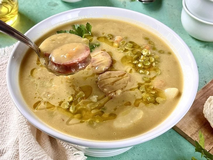 Porção de sopa sendo retirada com uma concha.