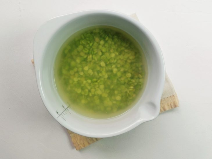Um recipiente com ervilhas e água quente.