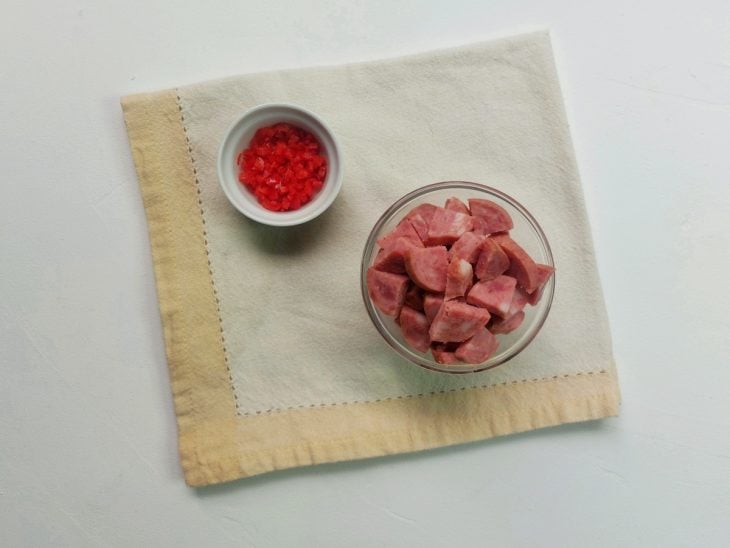 Recipientes com pimenta dedo-de-moça e calabresa picadas.