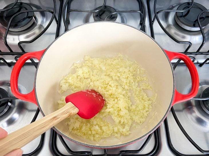 Uma panela contendo cebola e alho refogados.