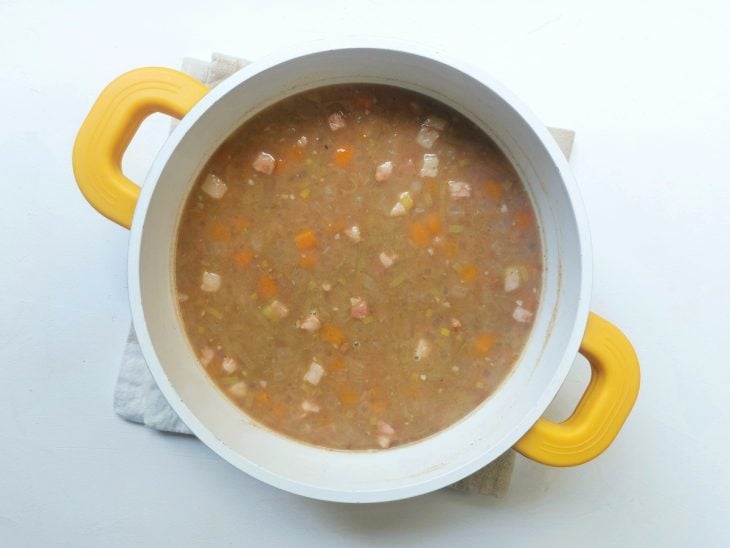 Panela com sopa de feijão e legumes misturados.