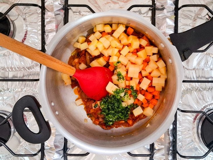 legumes picados entrando para a panela da sopa de feijão.