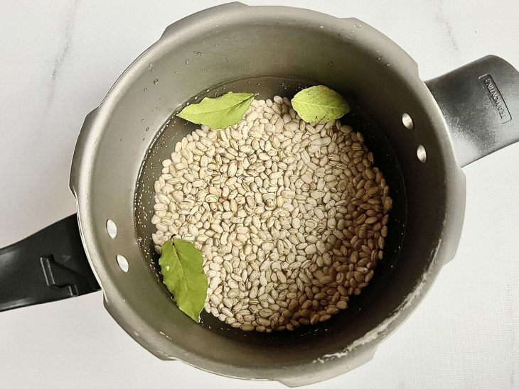 feijão e folhas de louro para cozinhar na panela de pressão.