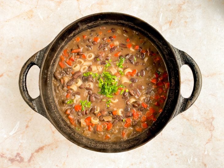 Sopa de feijão preto finalizada com cebolinha picada.