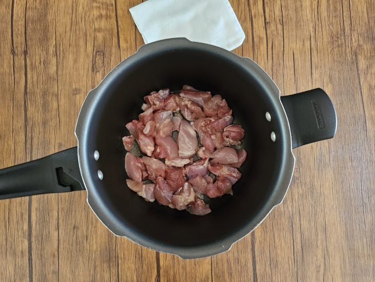 pedaços de frango em uma panela de pressão.