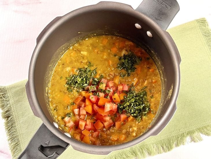 Tomate e salsinha adicionados com os ingredientes da sopa de lentilha.