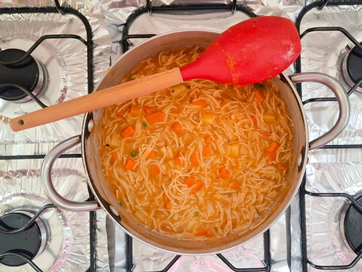 Batatas, macarrão e molho de tomate adicionados na panela.