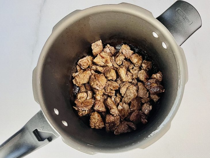 Carne refogando na panela.