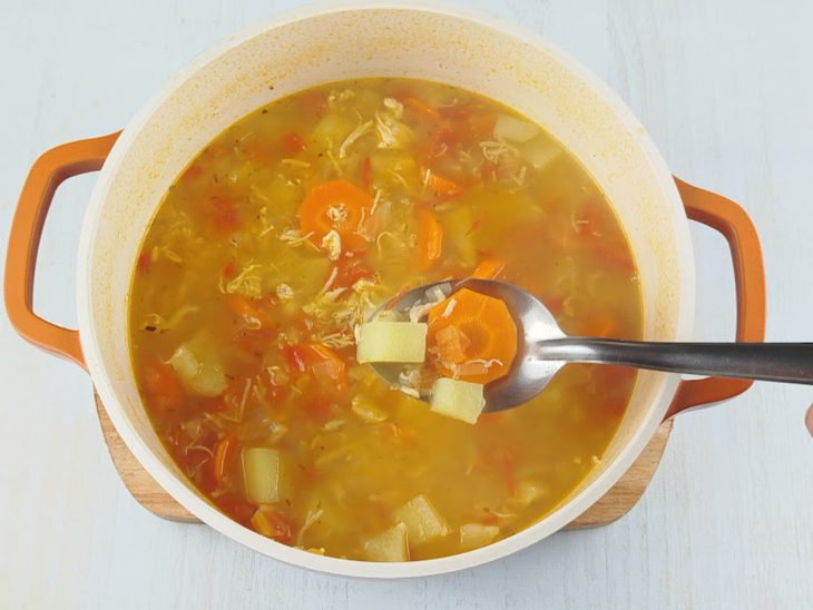Batatas e cenouras cozinhadas na panela com sopa.