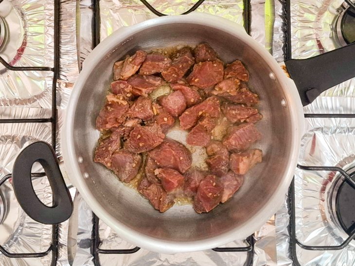 Carne com temperos na panela.