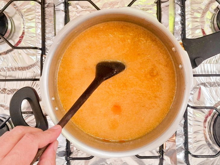 Mandioca e caldo adicionados na panela.