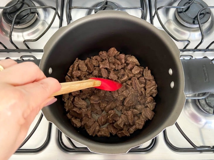 Panela com carne sendo mexida.