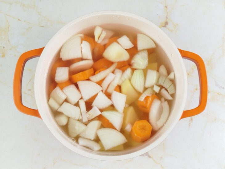 Legumes cobertos com água na panela.