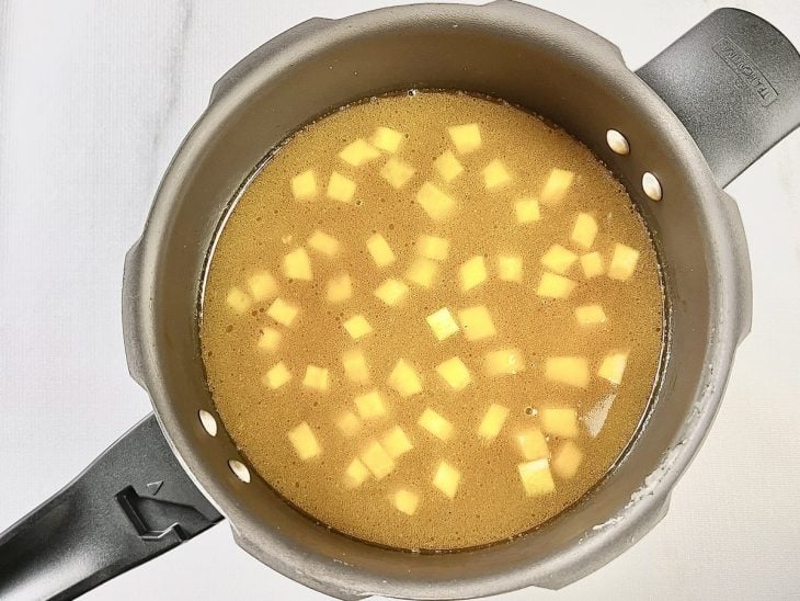 Legumes, macarrão e água adicionados na panela.