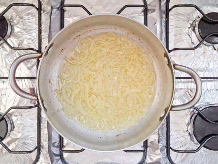 Cebola sendo refogada na panela.