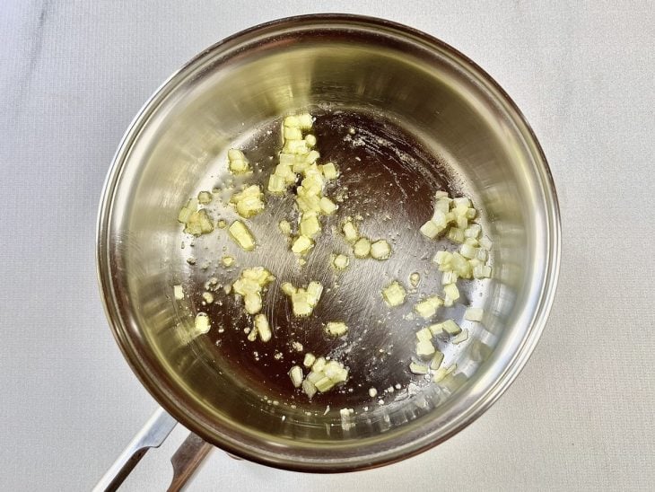 Uma panela com a cebola e o alho a dourar.