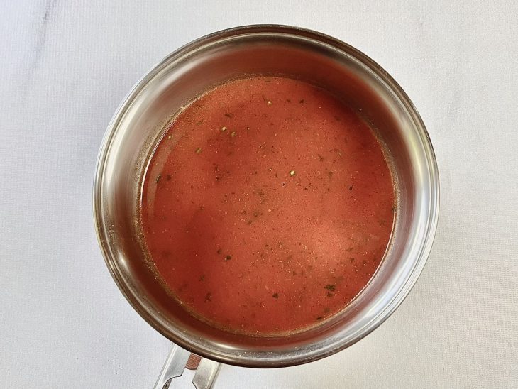 Uma panela com passata, água e cheiro-verde adicionados à mistura da sopa.