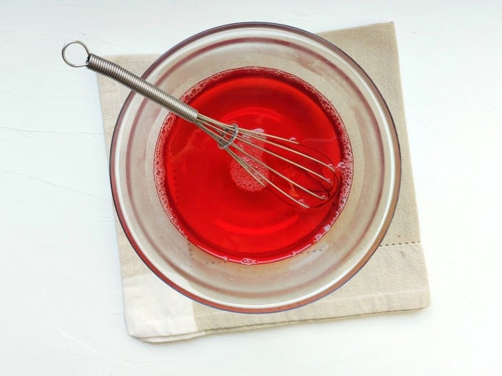 Gelatina de cor vermelha preparada em recipiente.