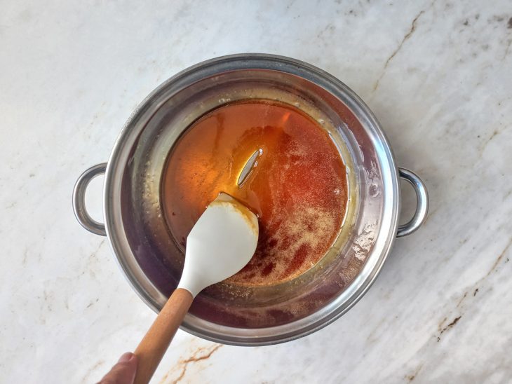 Numa panela, açúcar derretido em ponto de caramelo.