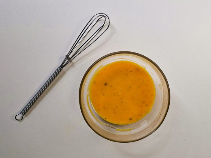 Gema, mostarda e pimenta misturadas em uma tigela.