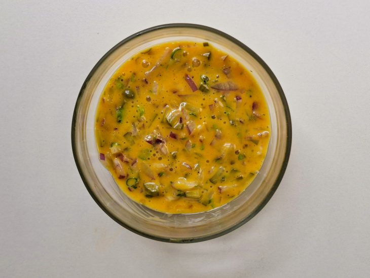 Picles, as alcaparras, a cebola roxa e parte da salsinha e da ciboulette adicionados a mistura.