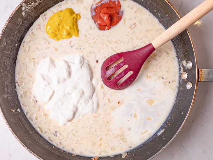 Ketchup, mostarda, leite de coco e creme de leite adicionados a frigideira.