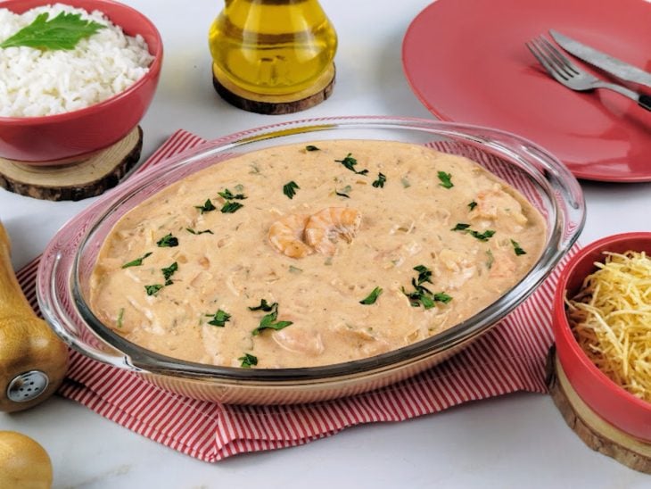 Strogonoff de camarão simples pronto para servir com arroz e batata palha.