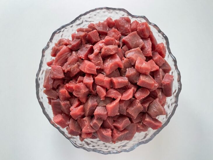 Carne cortada em cubos reservada numa tigela.