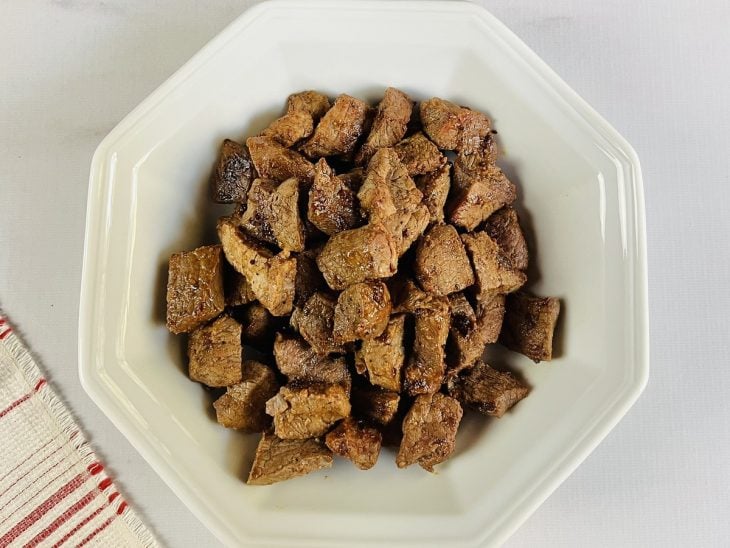Um recipiente com carne grelhada.