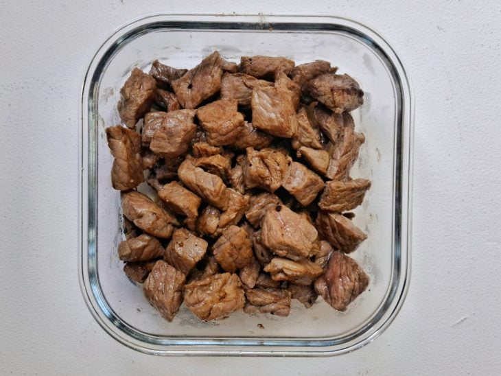 Carne temperada reservada em uma travessa.