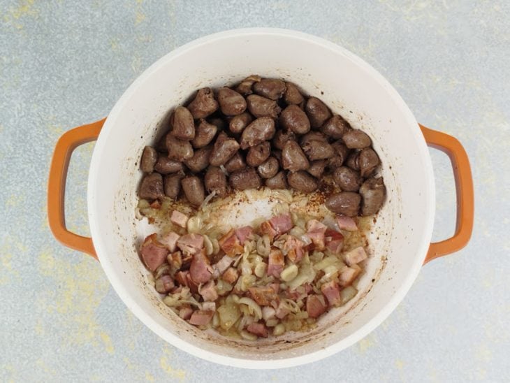 Cebola, alho e bacon sendo refogados na mesma panela até dourarem.