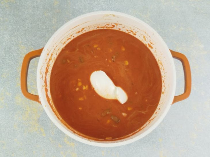Corações retornando à panela junto com creme de leite e requeijão, formando um creme.