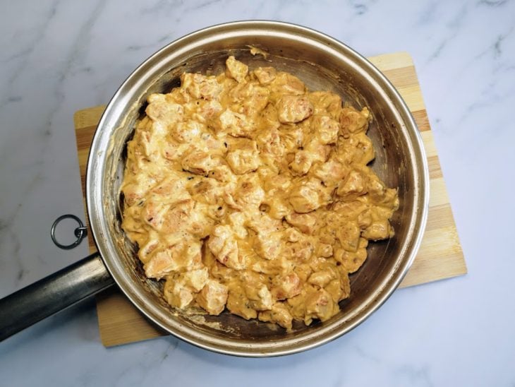 Uma frigideira com frango, temperos e creme de ricota light.