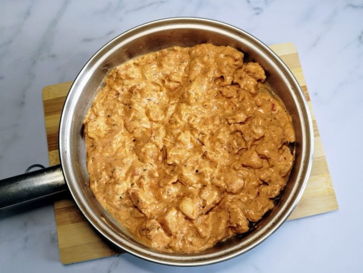 Uma frigideira com frango, temperos, creme de ricota light e molho de tomate zero.