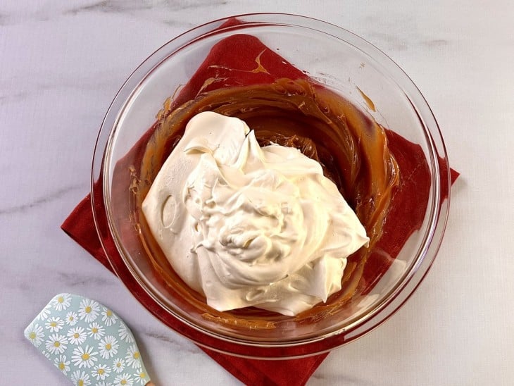 Recipiente com brigadeiro de doce de leite e chantilly.