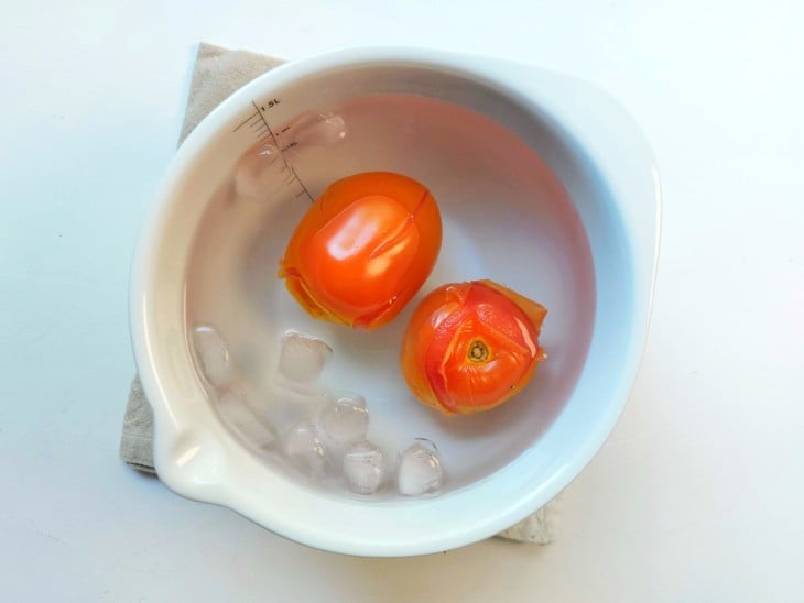 Tomates colocados em uma tigela com água e gelo.