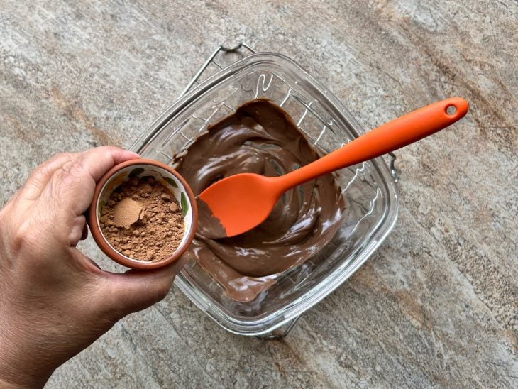 Cacau em pó para ser adicionado ao recipiente com chocolate derretido.