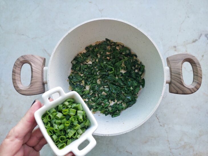 Cheiro-verde sendo adicionado na panela.