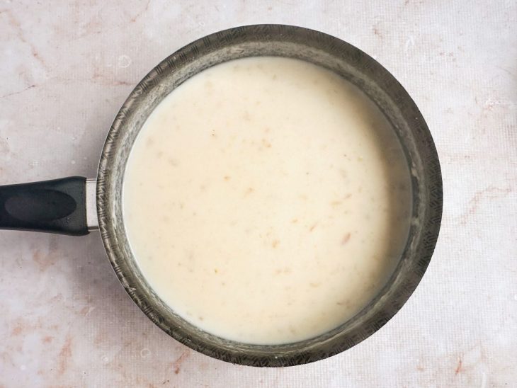 Leite sendo adicionado aos poucos.